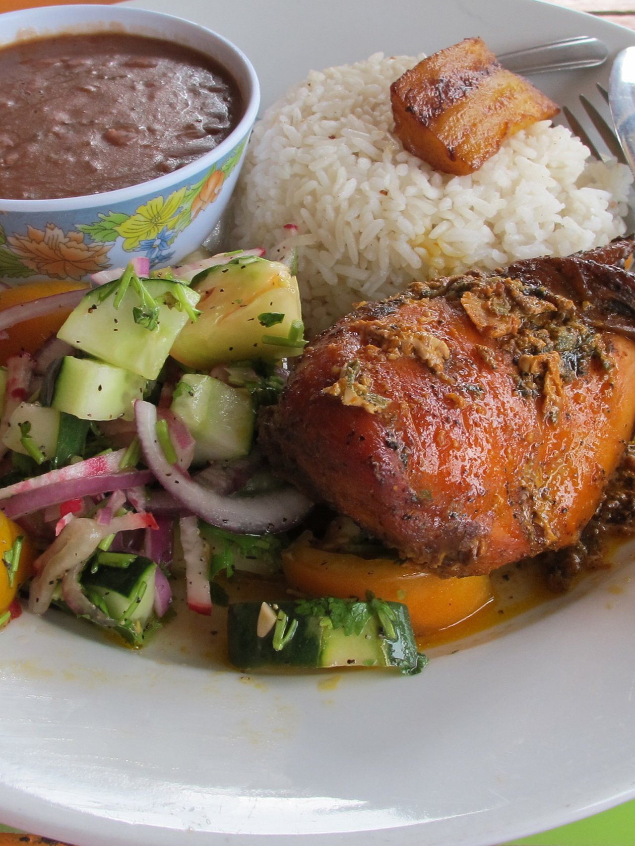 A typical Belizean lunch with salad, stew chicken and beans and rice
