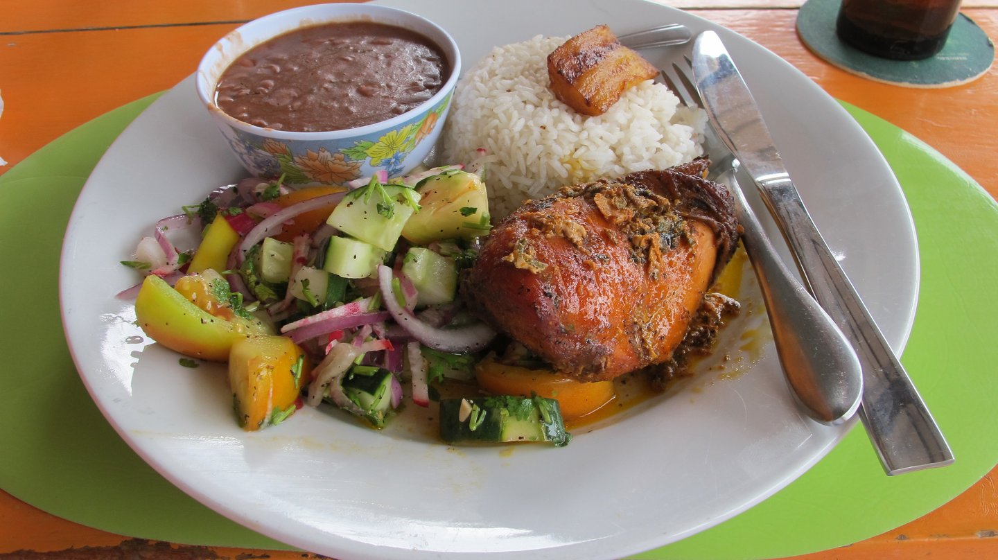 A typical Belizean lunch with salad, stew chicken and beans and rice