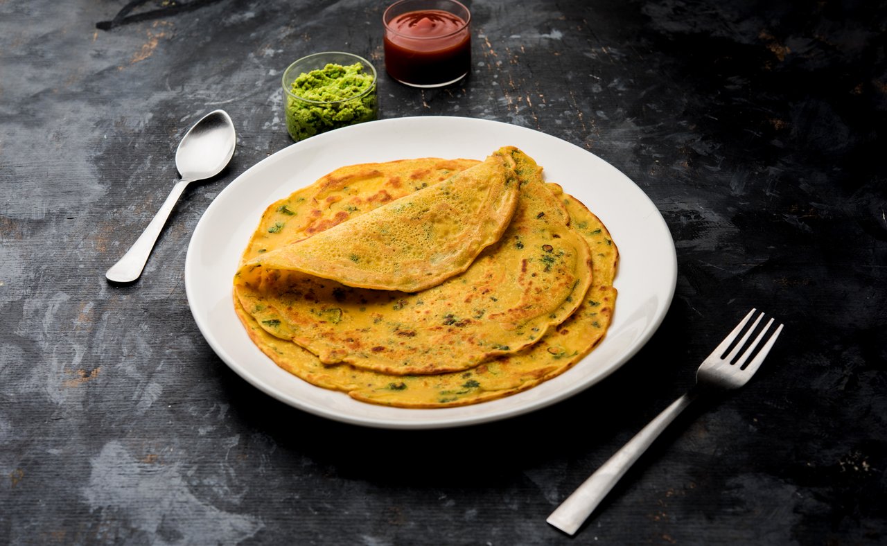 Besan chilla, a savoury pancake, served with sauces