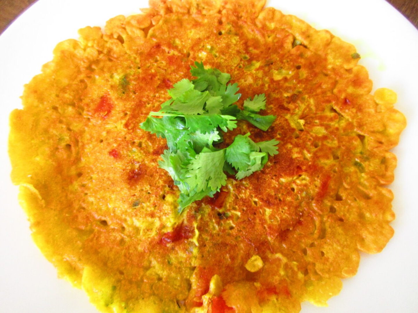 A whole besan chilla garnished with coriander 