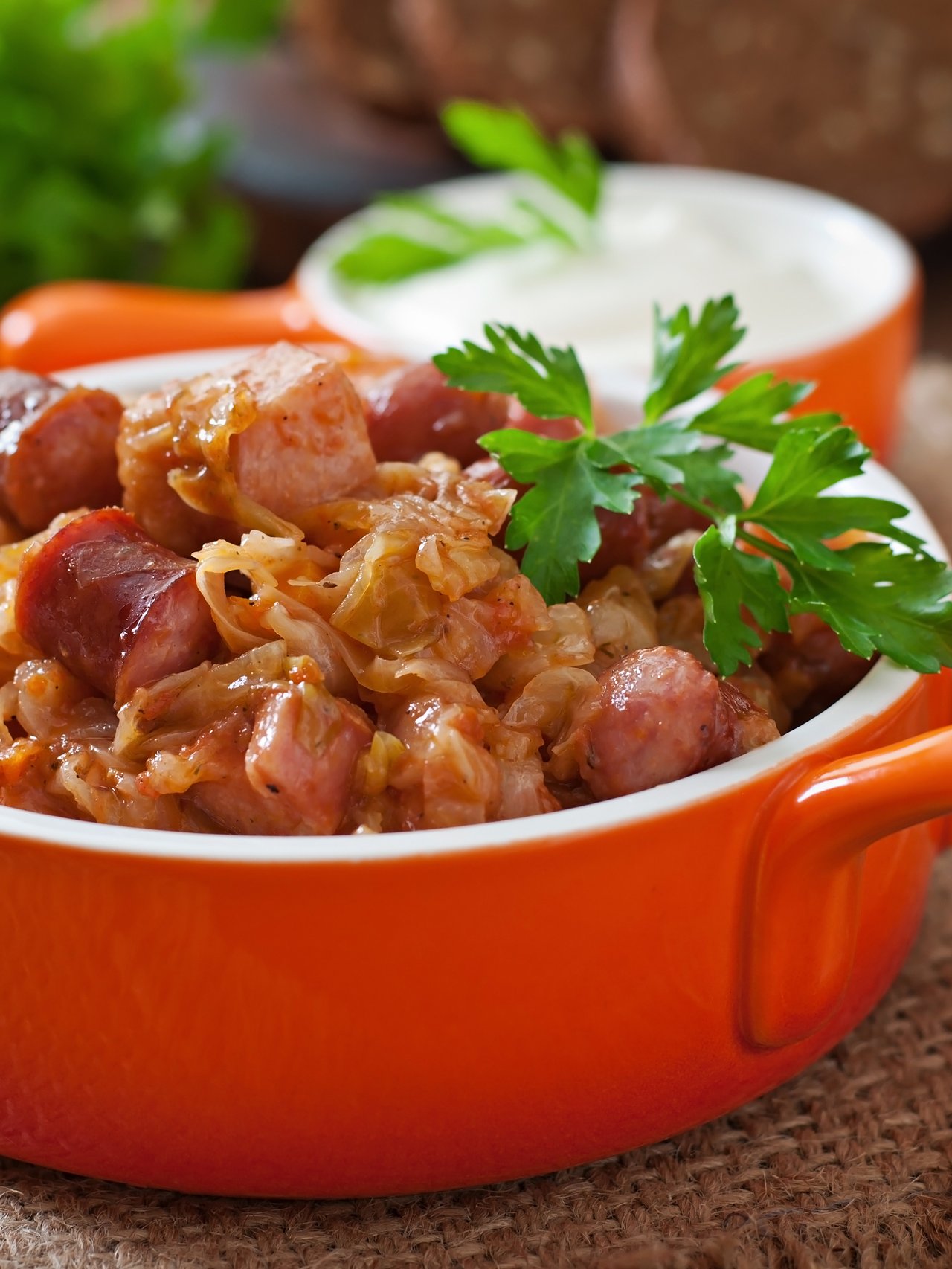 Bigos with sausage and bacon in a red dutch oven