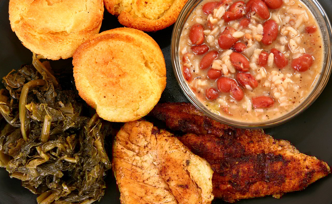 A platter of Cajun food including fish and red beans and rice