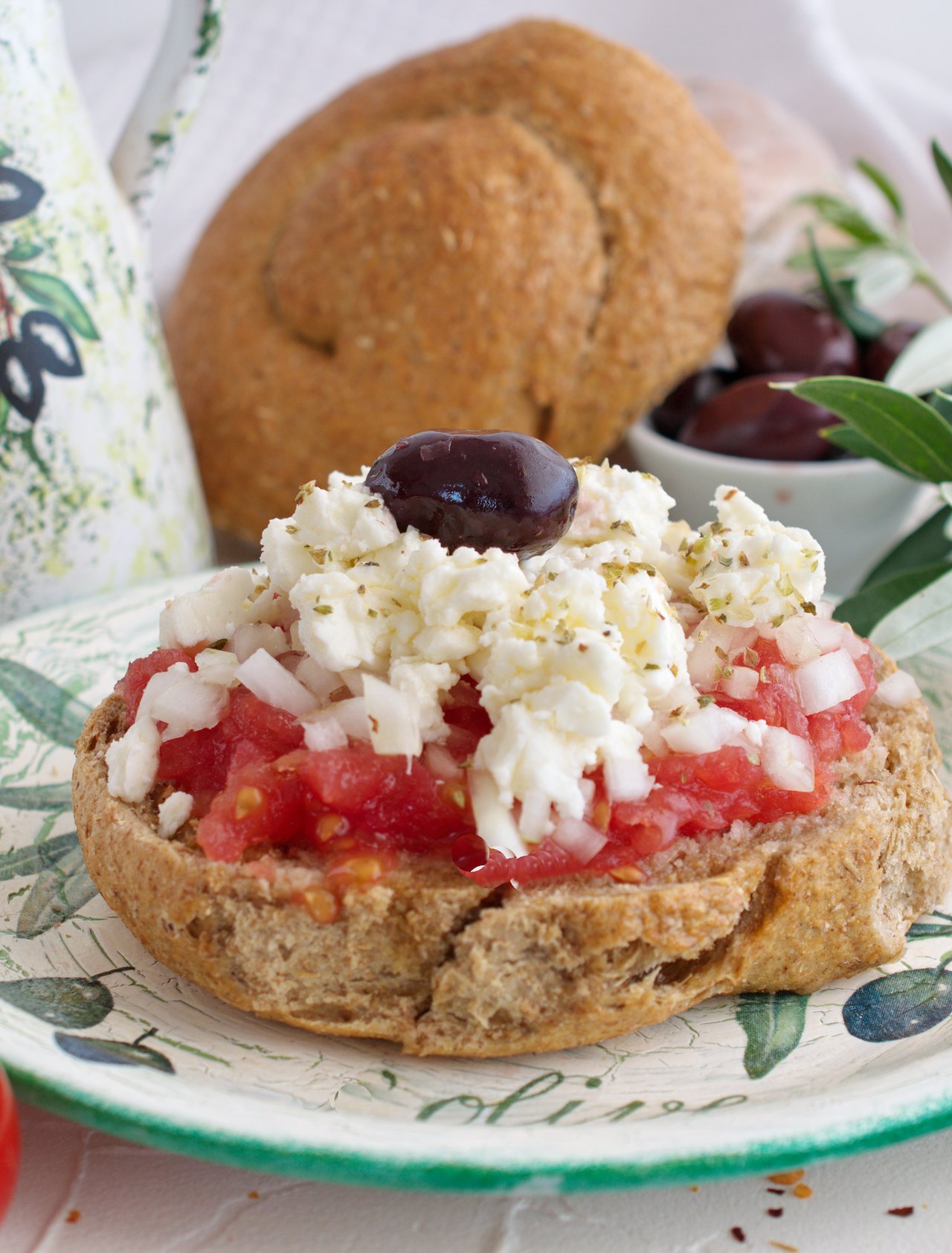 Dakos served with tomatoes and cheese on a pretty plate
