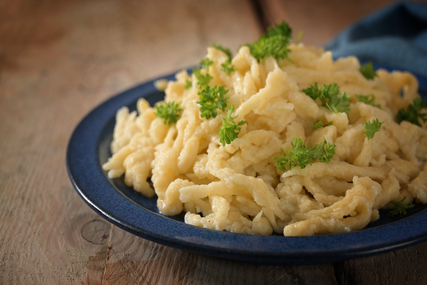 Homemade spaetzle, German egg noodles with cheese served with parsley garnish