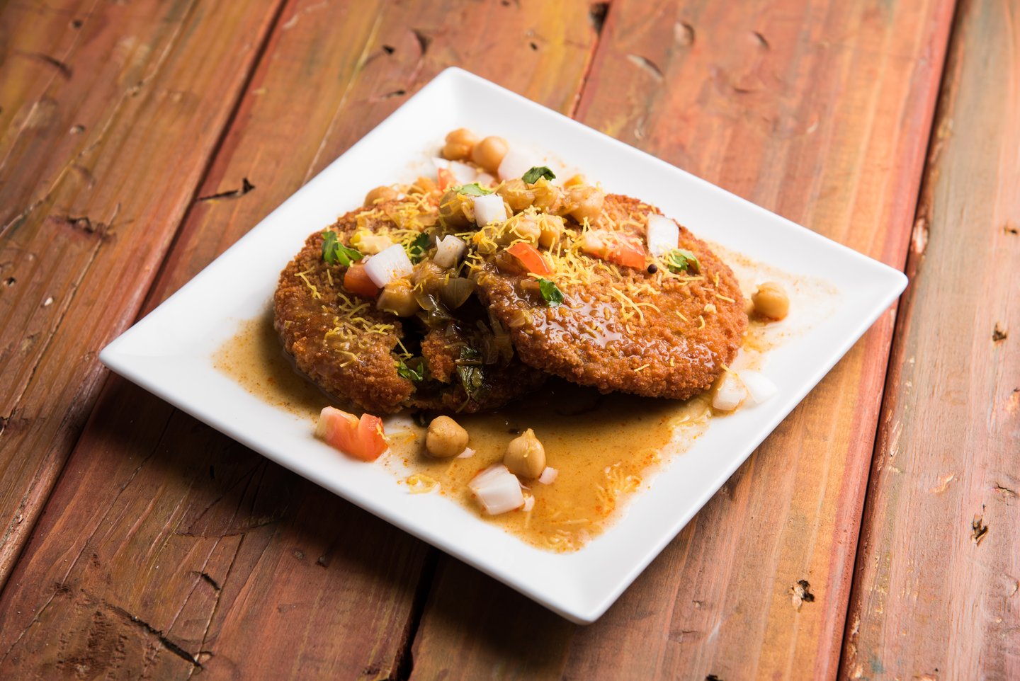 Aloo tikka on a plate covered in sauce