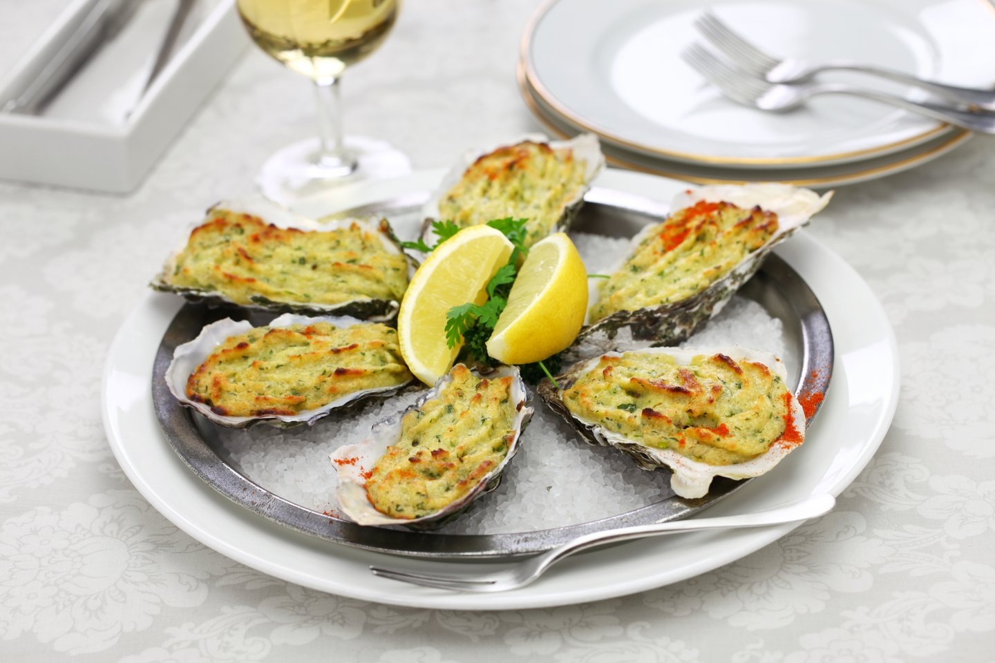 A dish of Oysters Rockefeller garnished with lemon