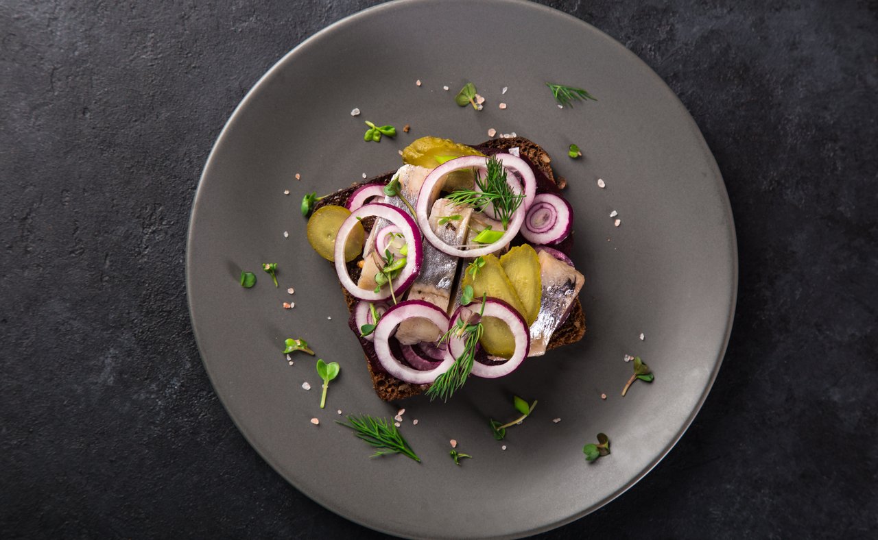 Pickled herring smorrebrod topped with red onions
