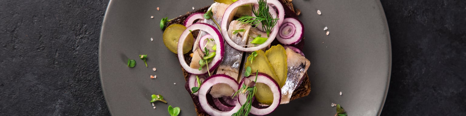 Pickled herring smorrebrod topped with red onions