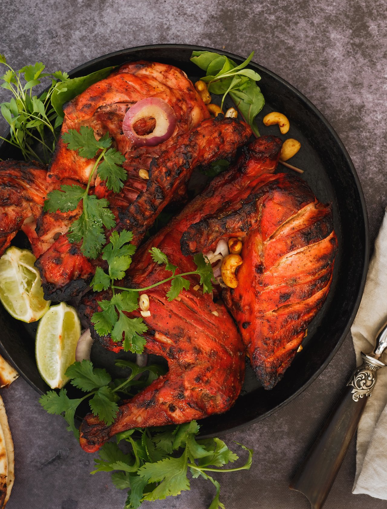 Tandoori chicken served with coriander, lemon wedges and naan