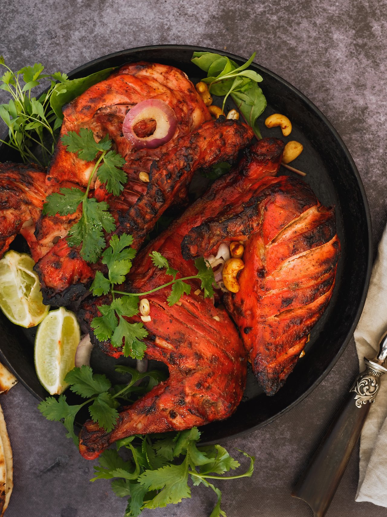 Tandoori chicken served with coriander, lemon wedges and naan