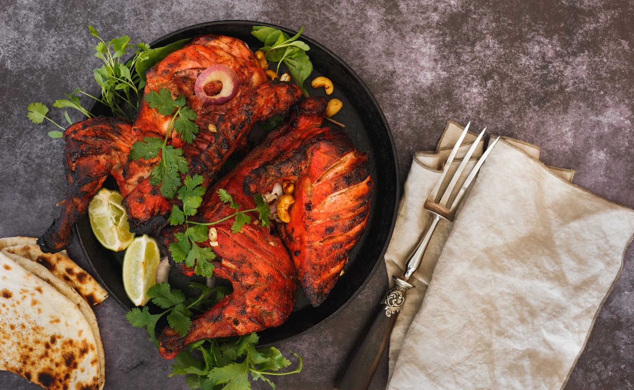 Tandoori chicken served with coriander, lemon wedges and naan