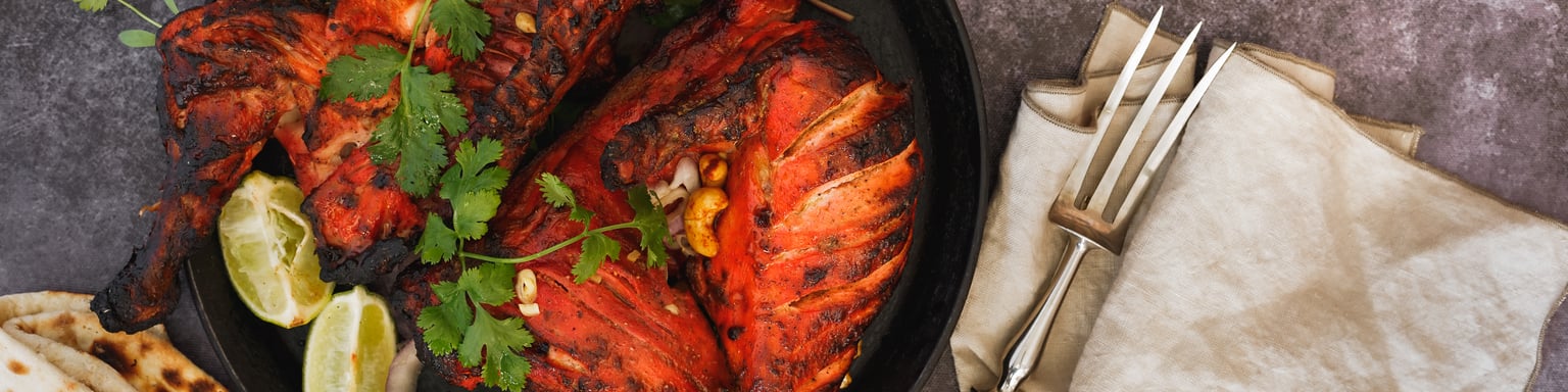 Tandoori chicken served with coriander, lemon wedges and naan