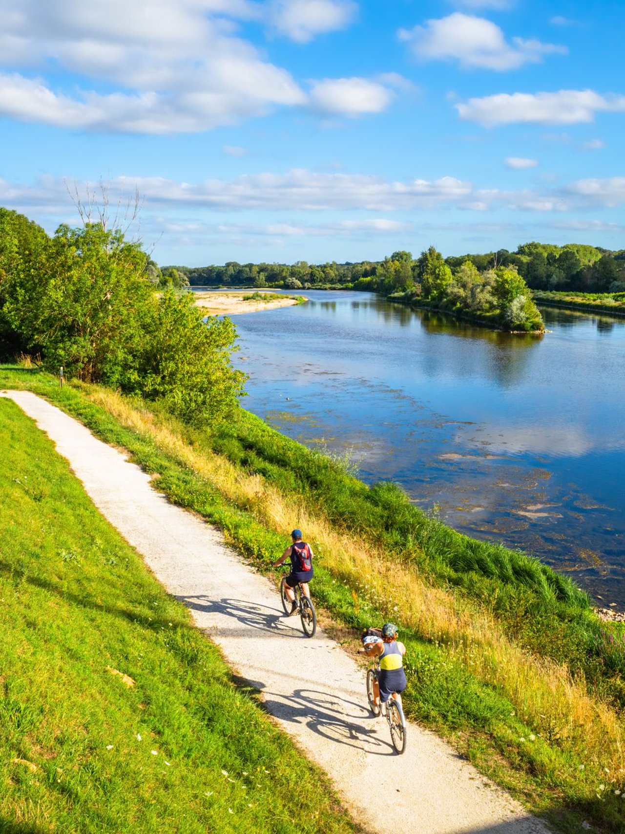 People cycling along the Loire River in Chatilllon sur Loire, France.