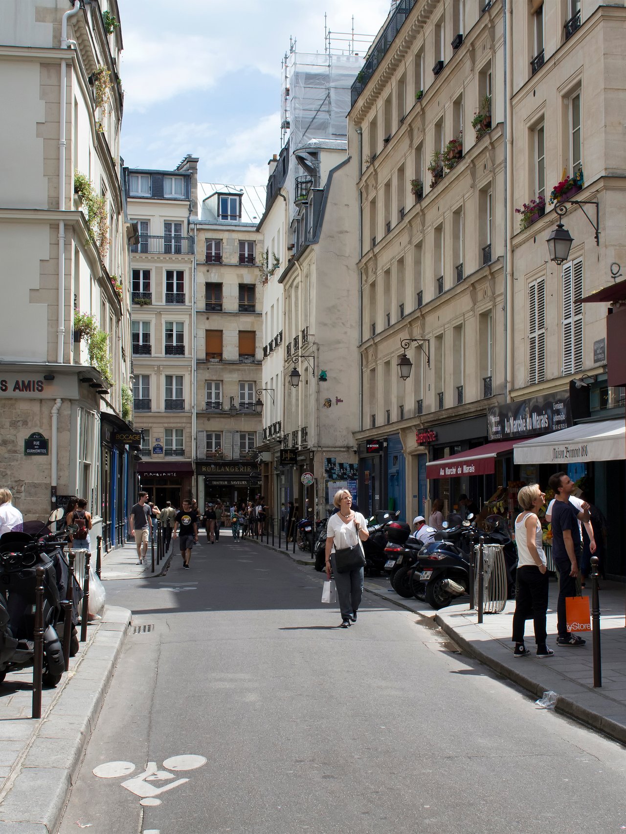 People walk on one of streets of Le Marais district of Paris.