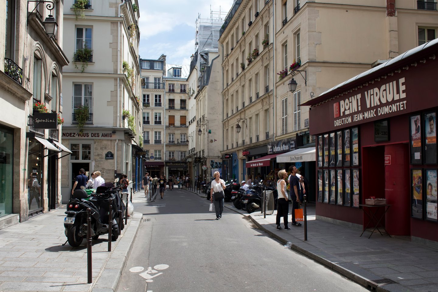 People walk on one of streets of Le Marais district of Paris. 