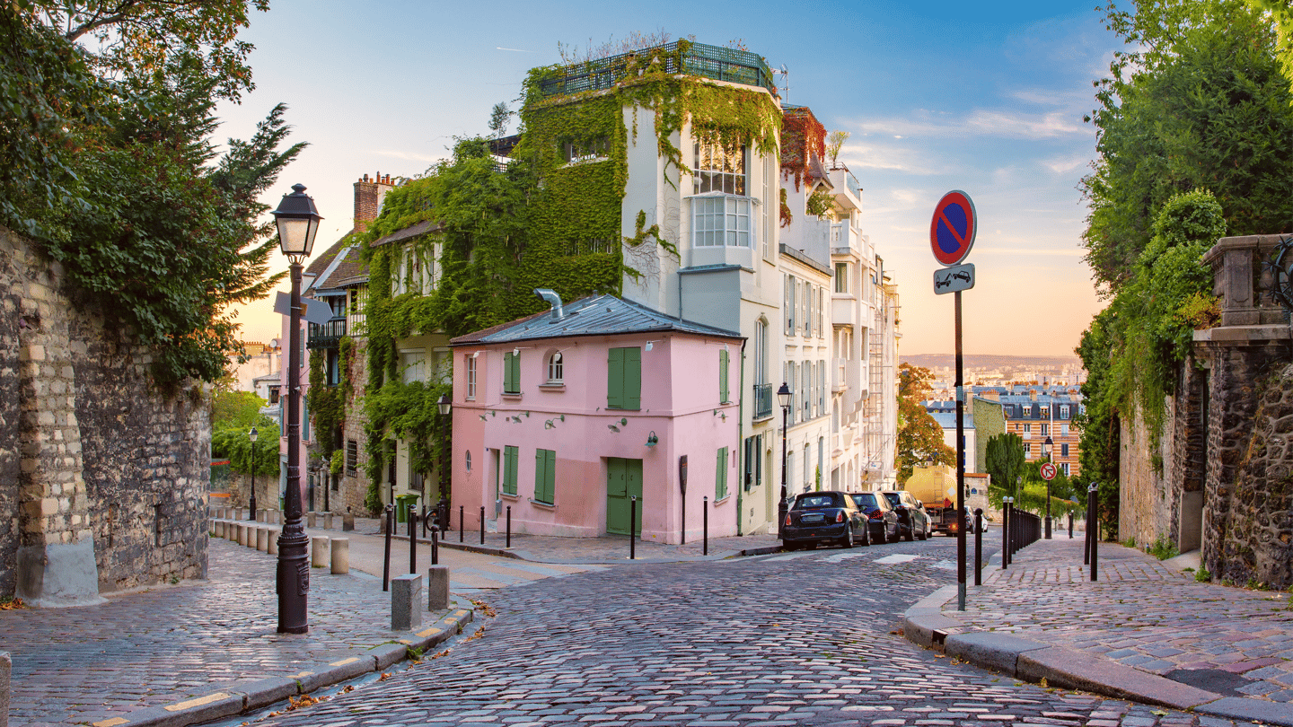 Old street with pink house at sunrise in Montmartre in Paris, France