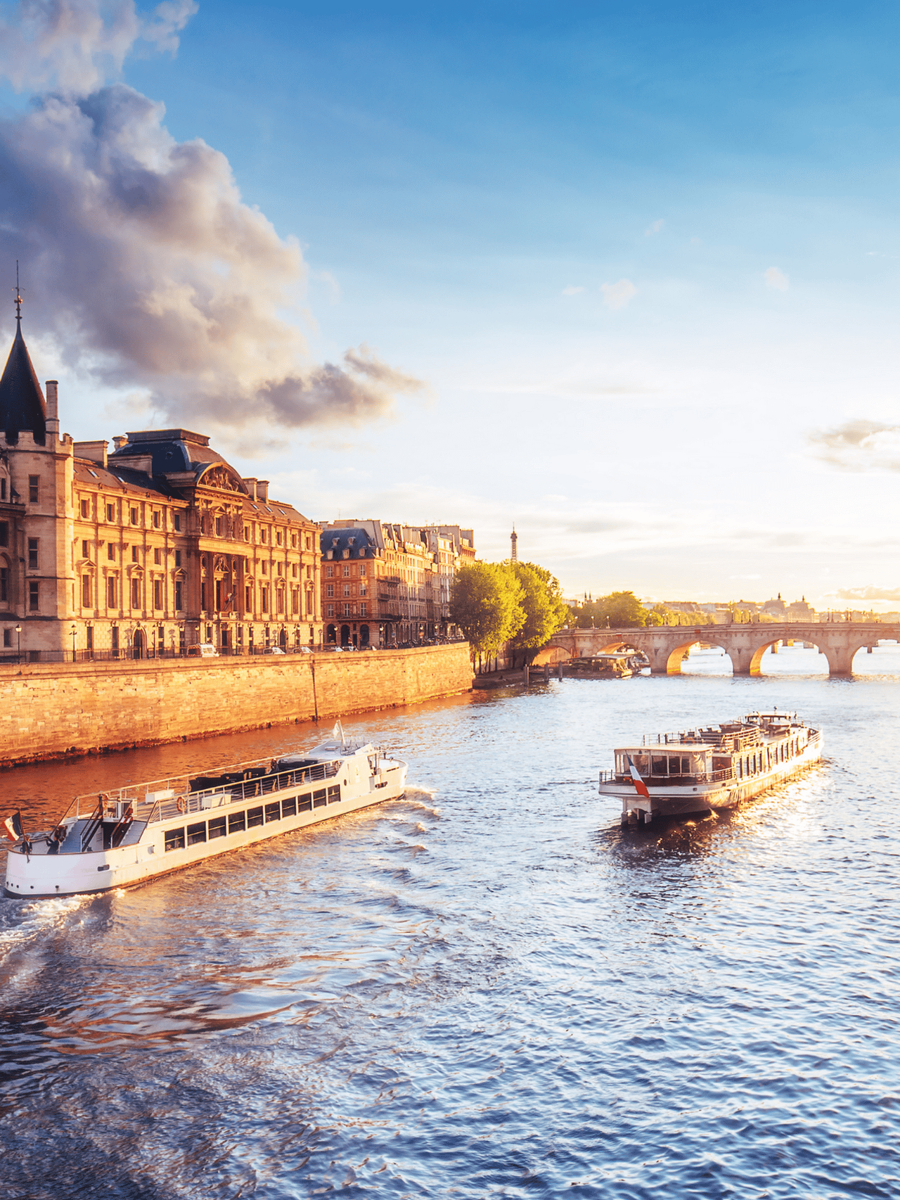 Dramatic sunset over river Seine in Paris, France, with Conciergerie and Pont Neuf.