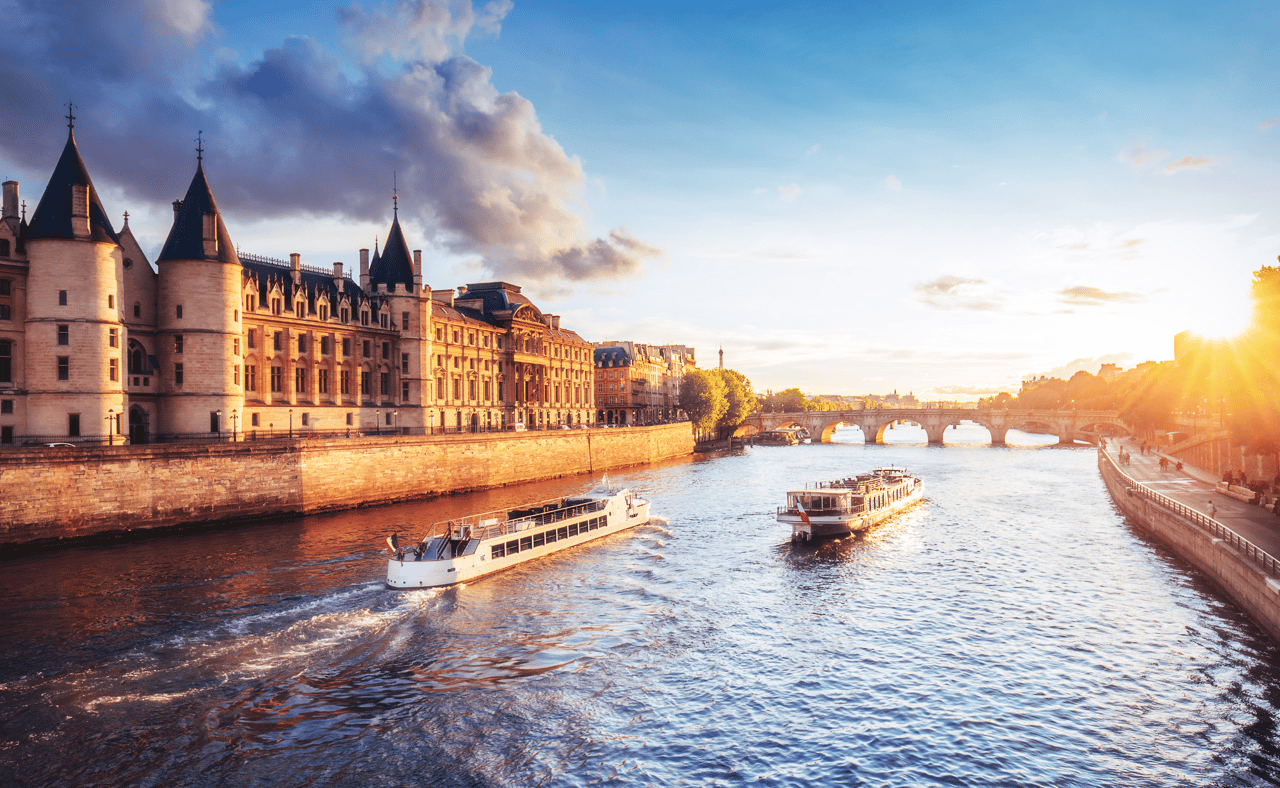 Dramatic sunset over river Seine in Paris, France, with Conciergerie and Pont Neuf.