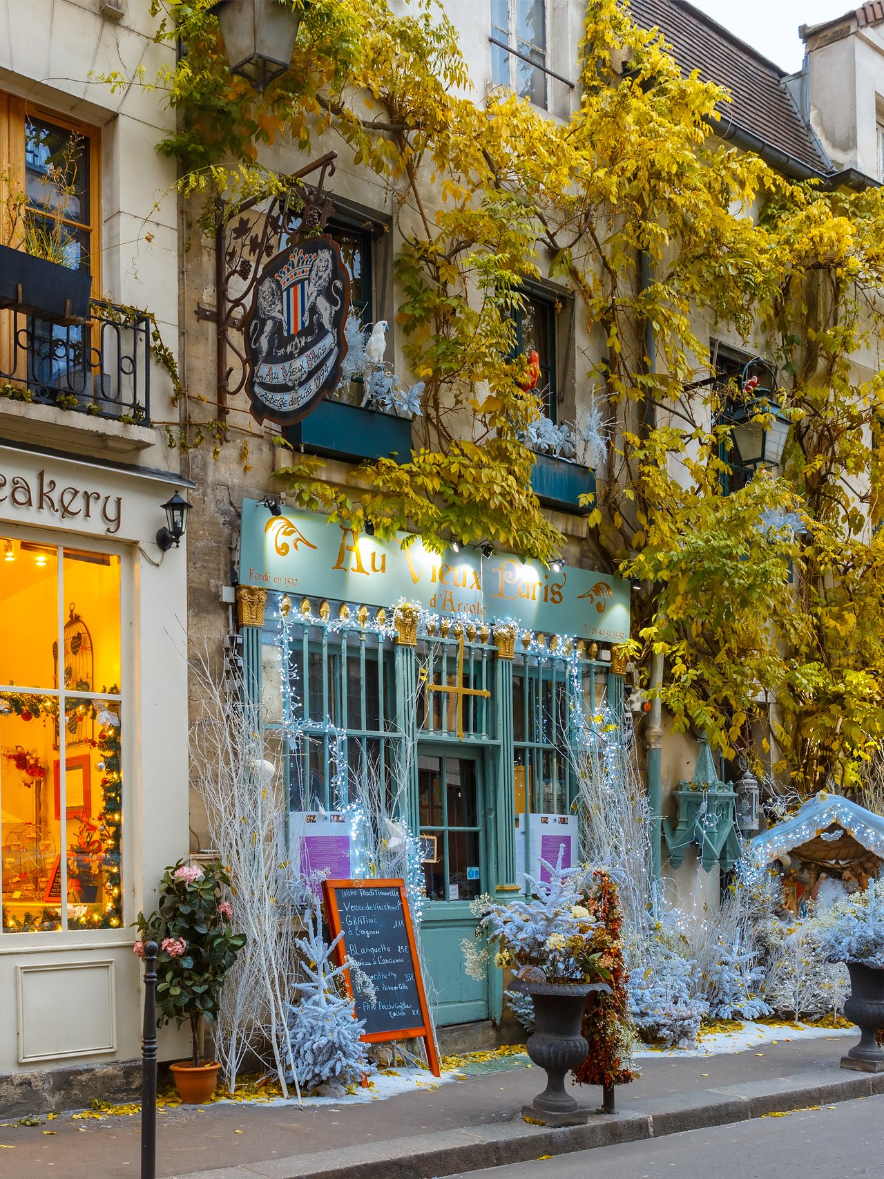 Cafes on a street in Paris decorated for Christmas