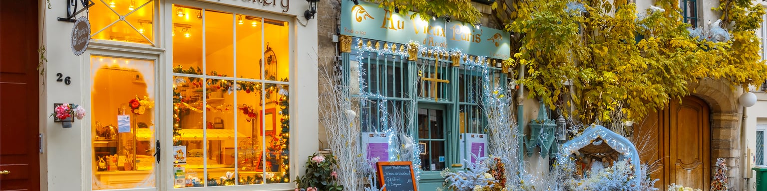 Cafes on a street in Paris decorated for Christmas