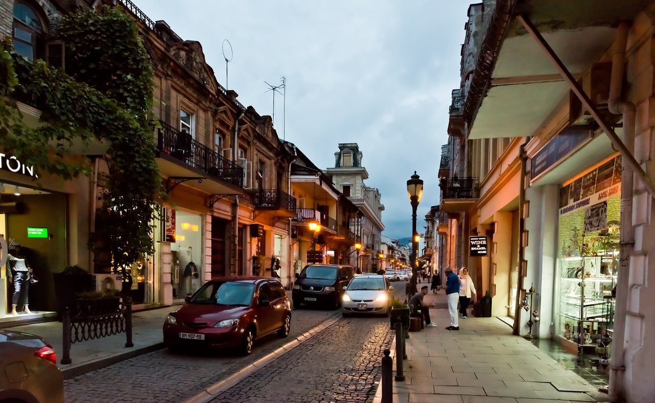 People and cars on a street in Batumi, Georgia at night
