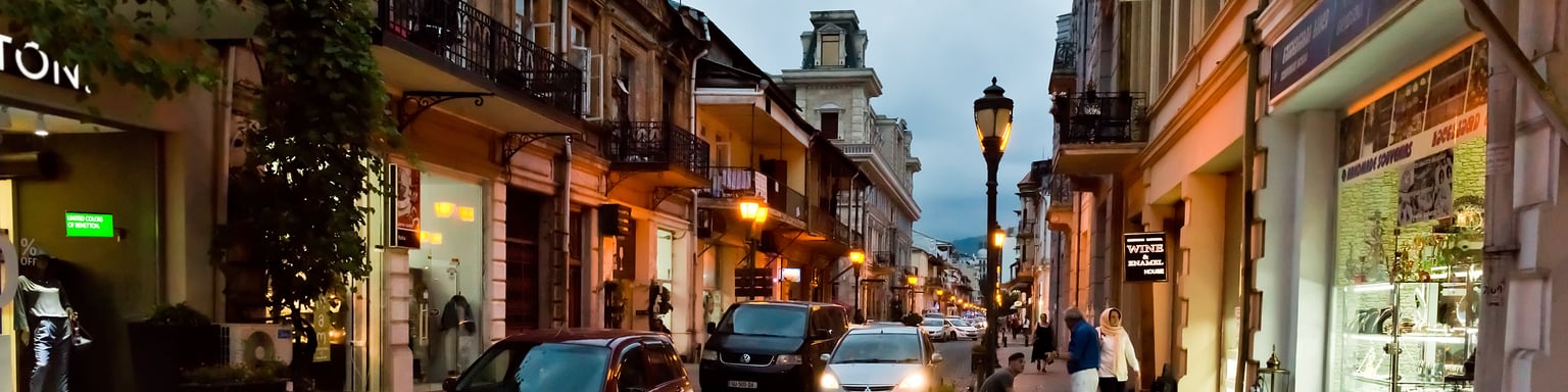 People and cars on a street in Batumi, Georgia at night