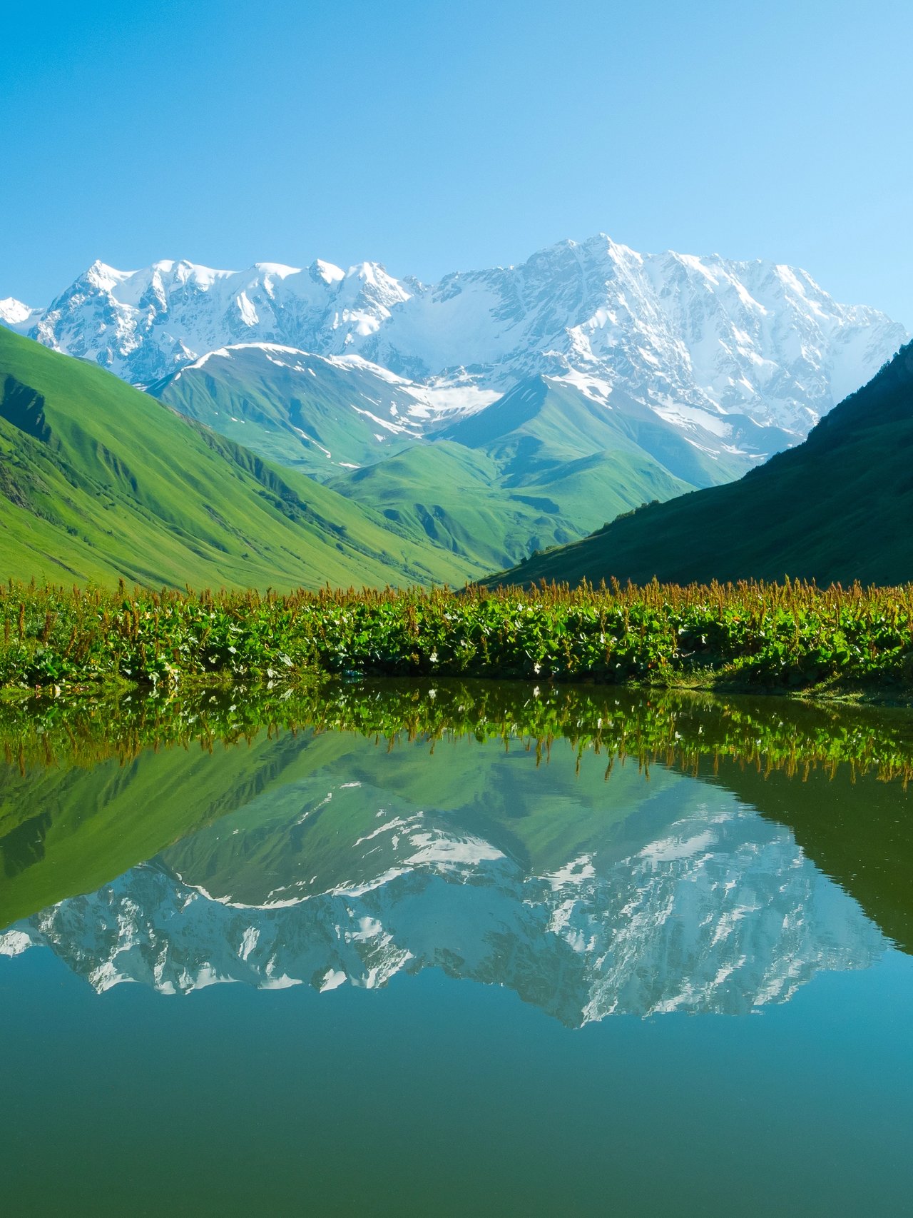 Mountains reflected in an alpine lake near Ushguli in the Svaneti region of Georgia