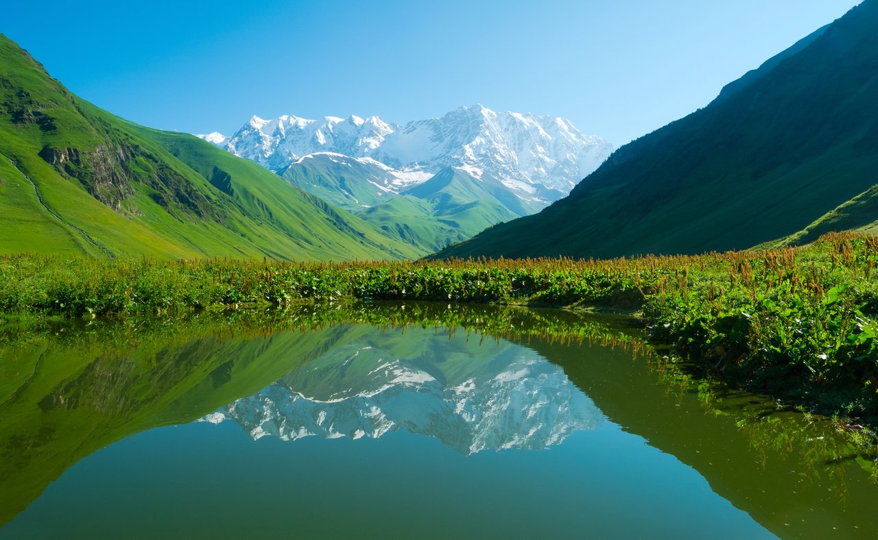 Mountains reflected in an alpine lake near Ushguli in the Svaneti region of Georgia
