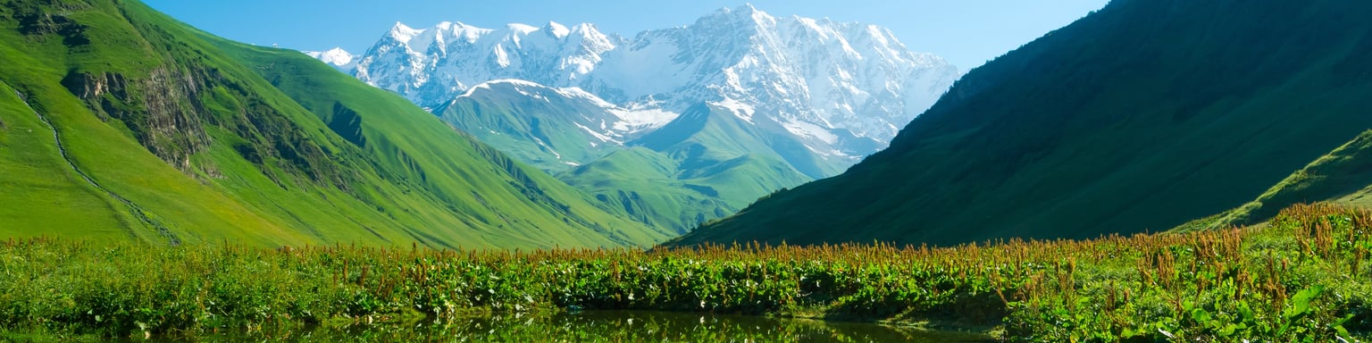 Mountains reflected in an alpine lake near Ushguli in the Svaneti region of Georgia