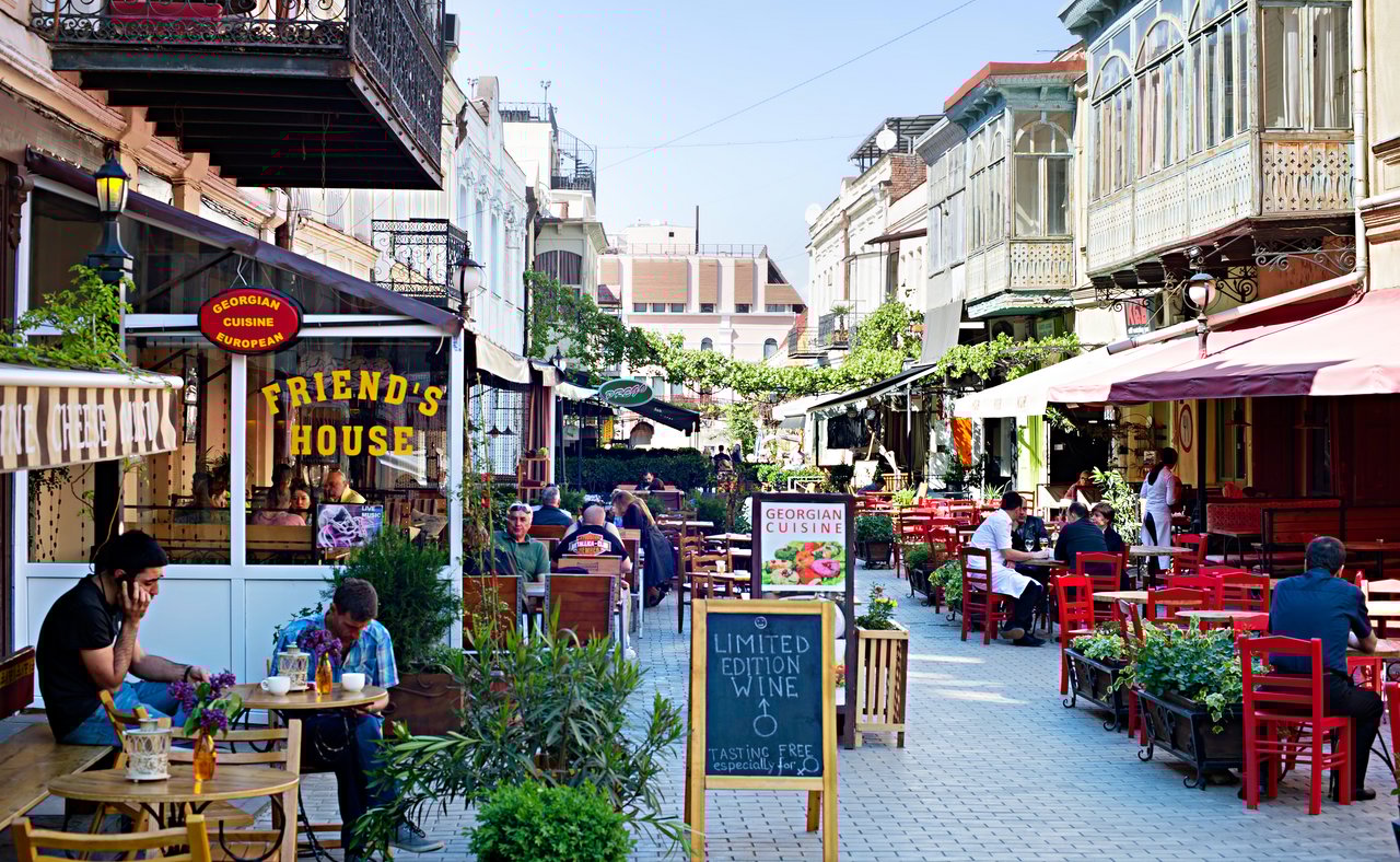 People sitting at outdoor restaurants in the Old Town of Tbilisi, Georgia.