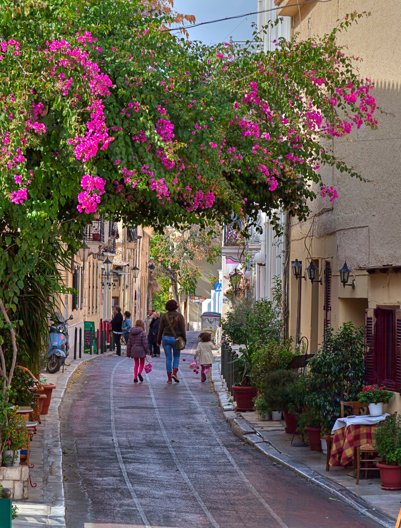 A pretty street in Plaka, Athens with a family walking in the distance