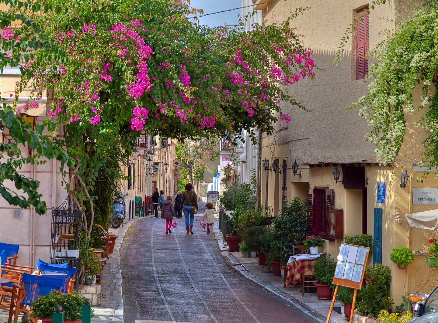 A pretty street in Plaka, Athens with a family walking in the distance