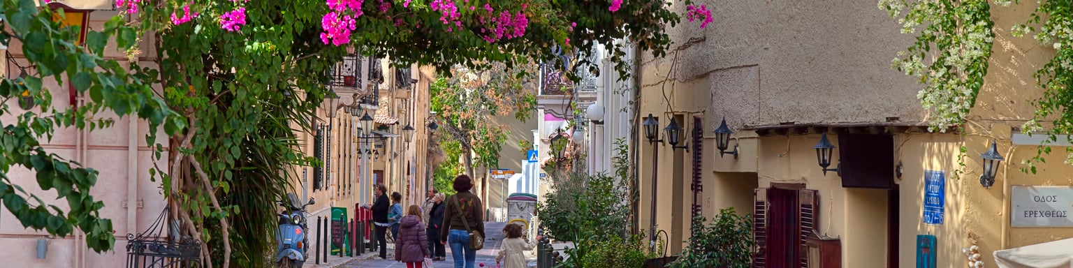 A pretty street in Plaka, Athens with a family walking in the distance