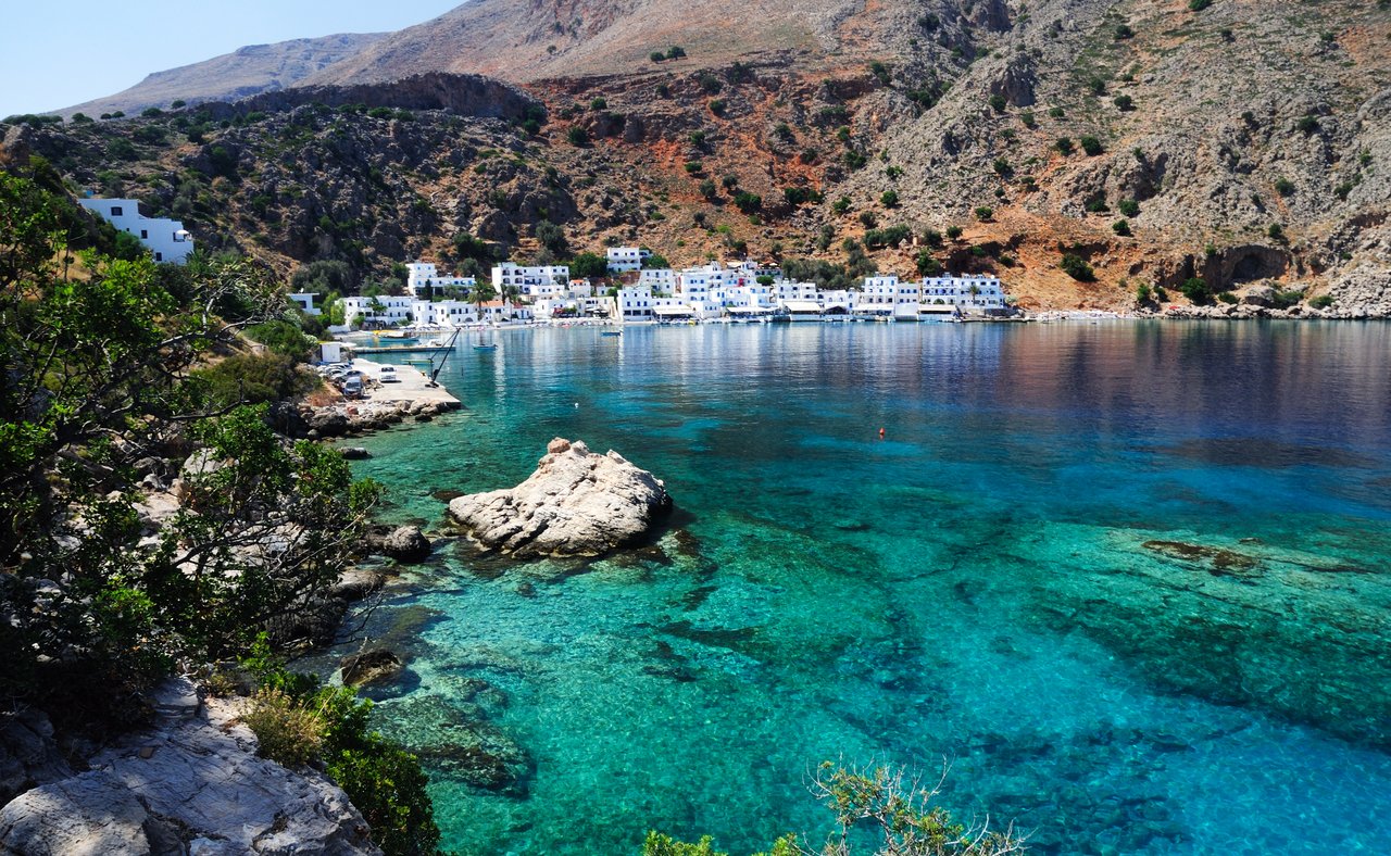 Blue water on Crete's southern coastline with the village of Loutro in the distance.