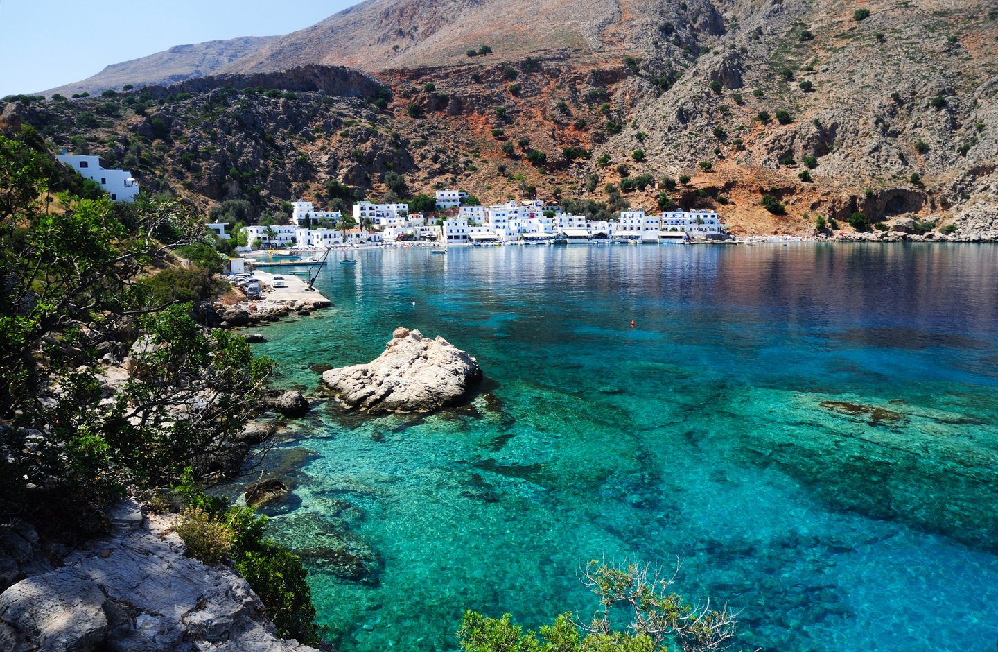 Blue water on Crete's southern coastline with the village of Loutro in the distance.