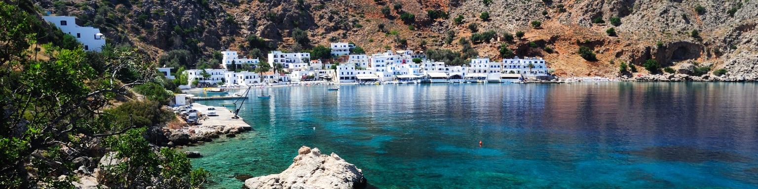 Blue water on Crete's southern coastline with the village of Loutro in the distance.