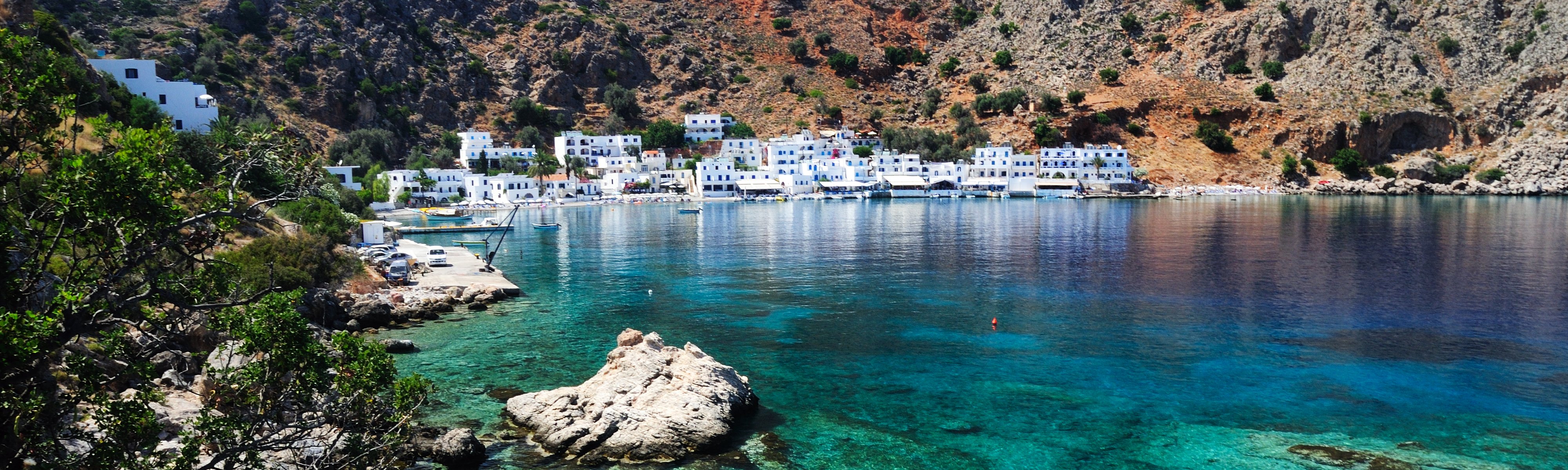 Blue water on Crete's southern coastline with the village of Loutro in the distance.