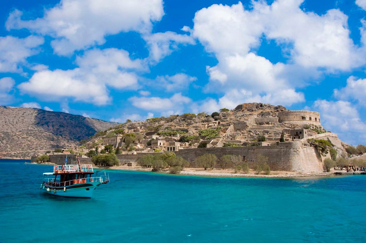 A boat in front of Spinalonga Island in Crete.