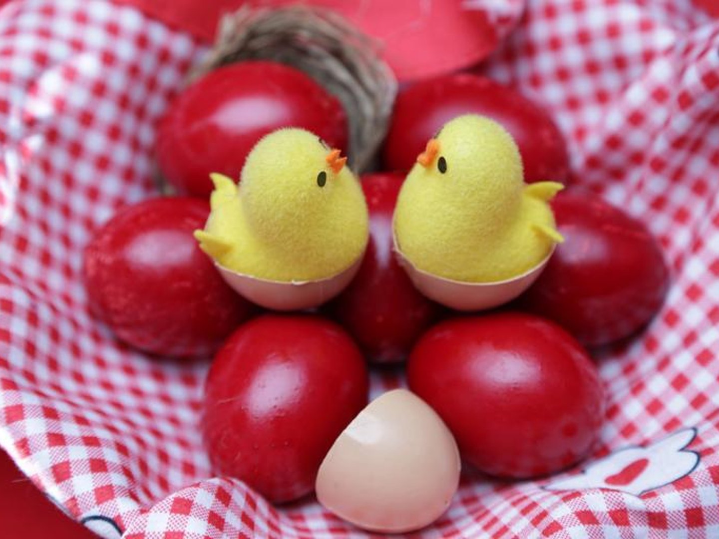Toy chicks sitting on red eggs