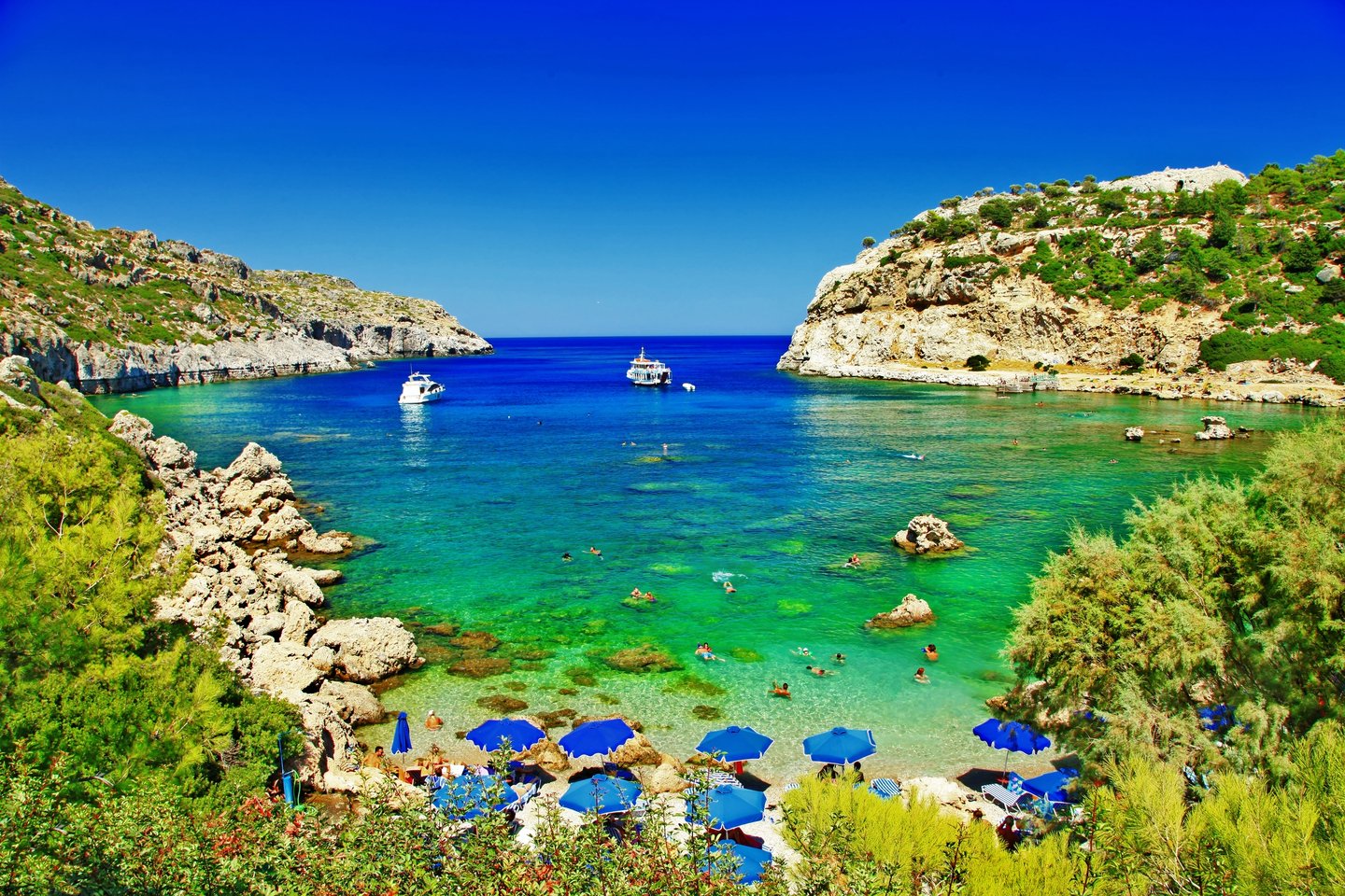 People swimming in a cove in Rhodes, Greece.