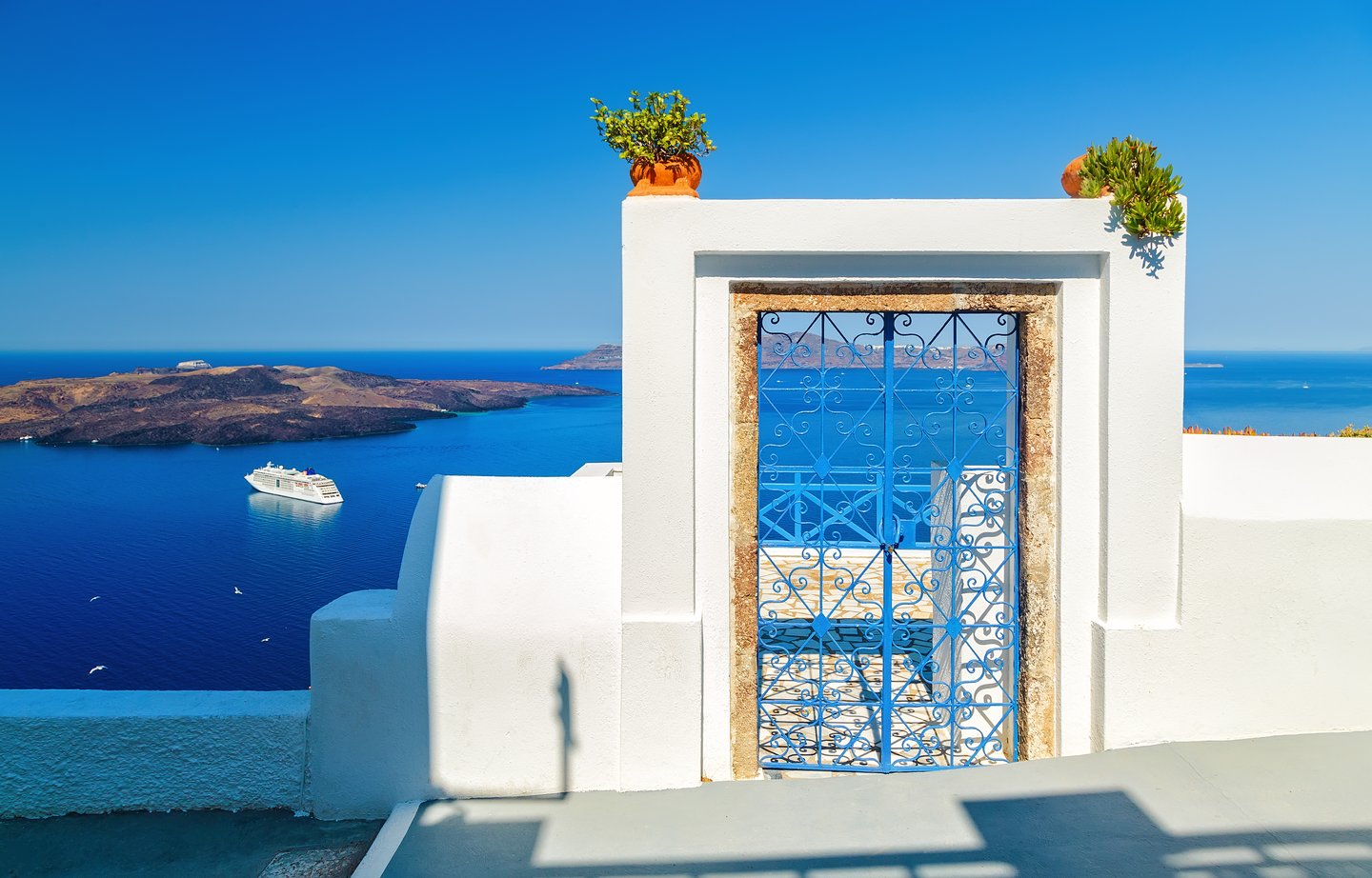 Blue gate on the clifftop in Santorini, Greece