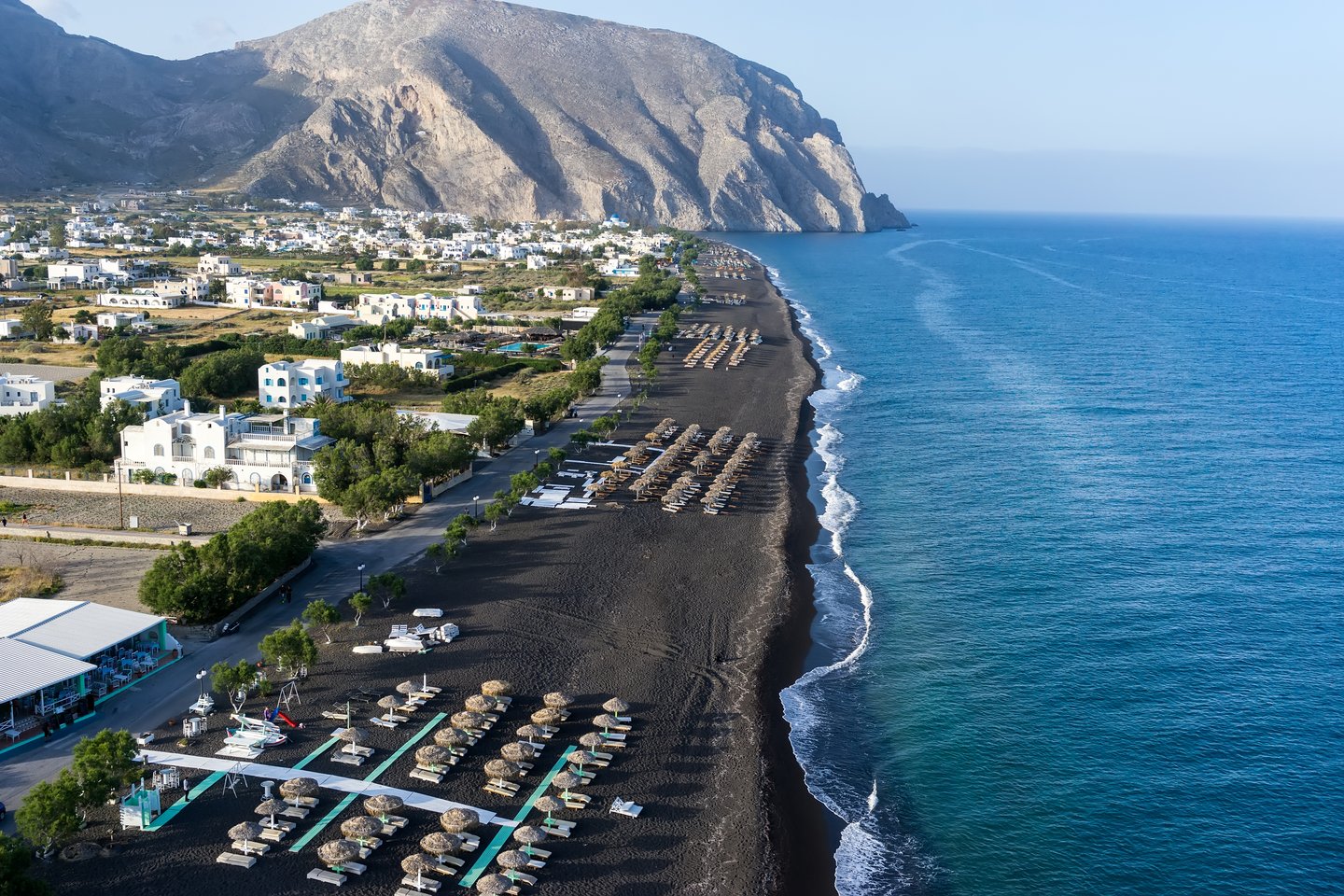 An aerial view of the black sand beach of Perissa in Santorini, Greece