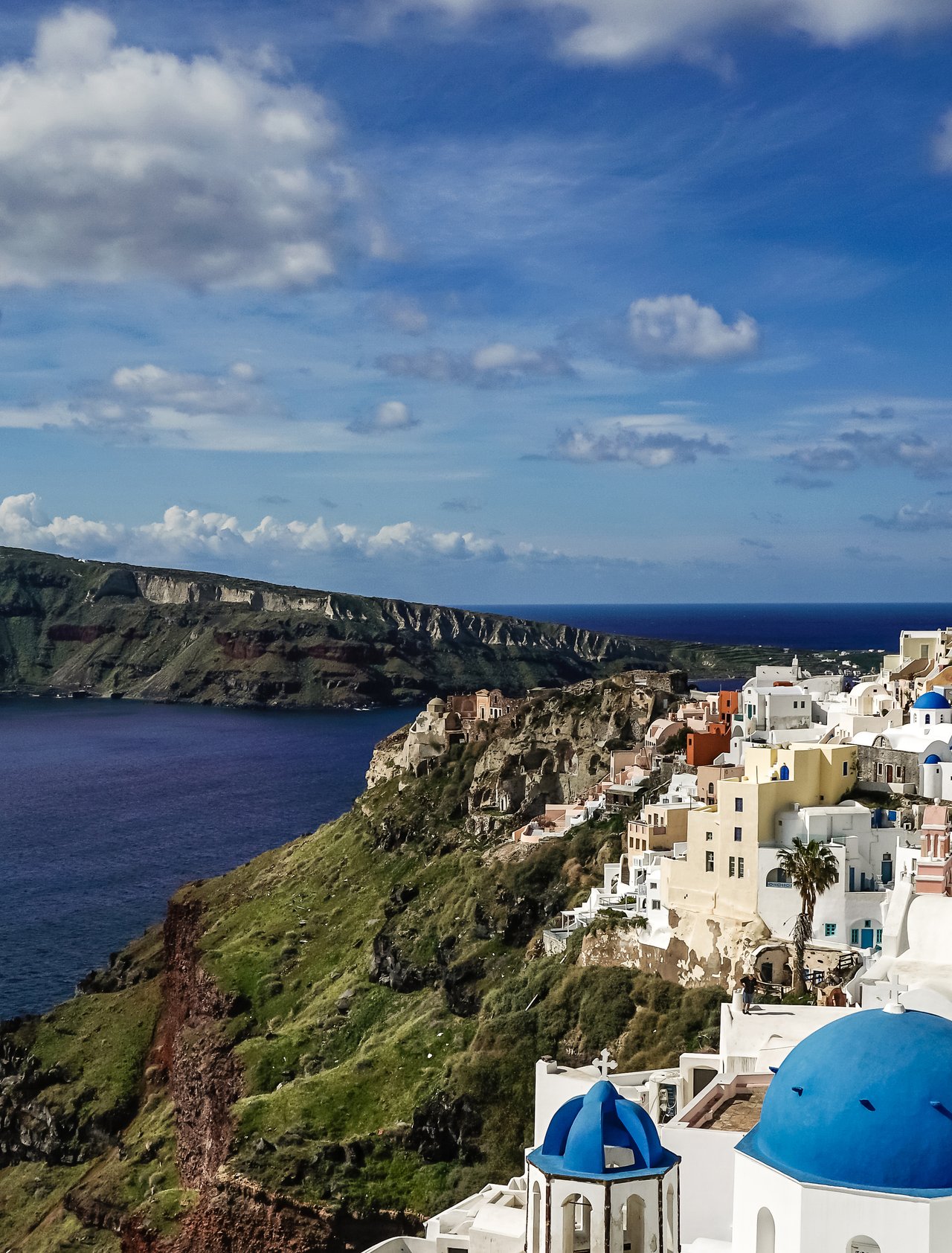 Blue and white rooftops in Santorini with the caldera in the background