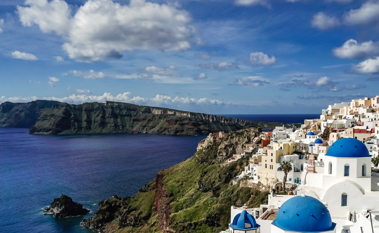 Blue and white rooftops in Santorini with the caldera in the background