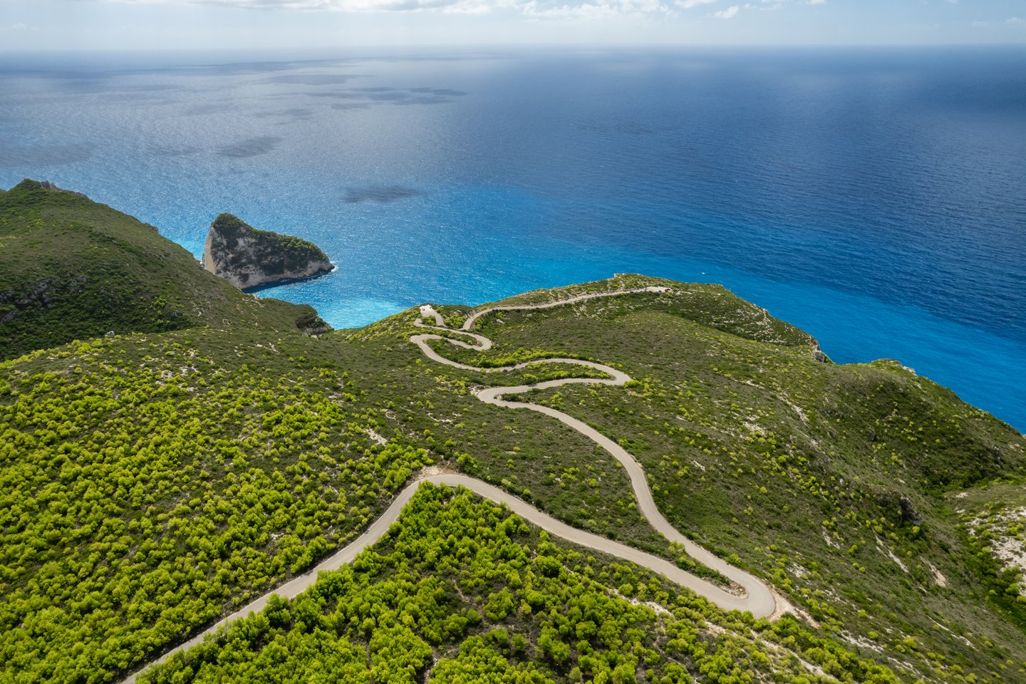 Looking down at a winding road on a cliff in Zakynthos, Greece.