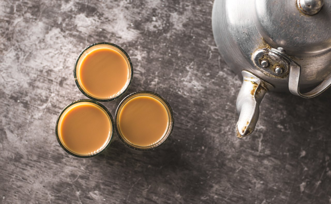 Spiced Indian tea in glass cups with a metal kettle 