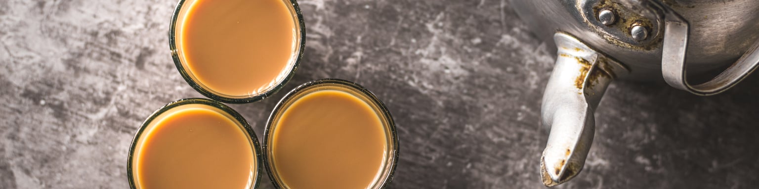 Spiced Indian tea in glass cups with a metal kettle 