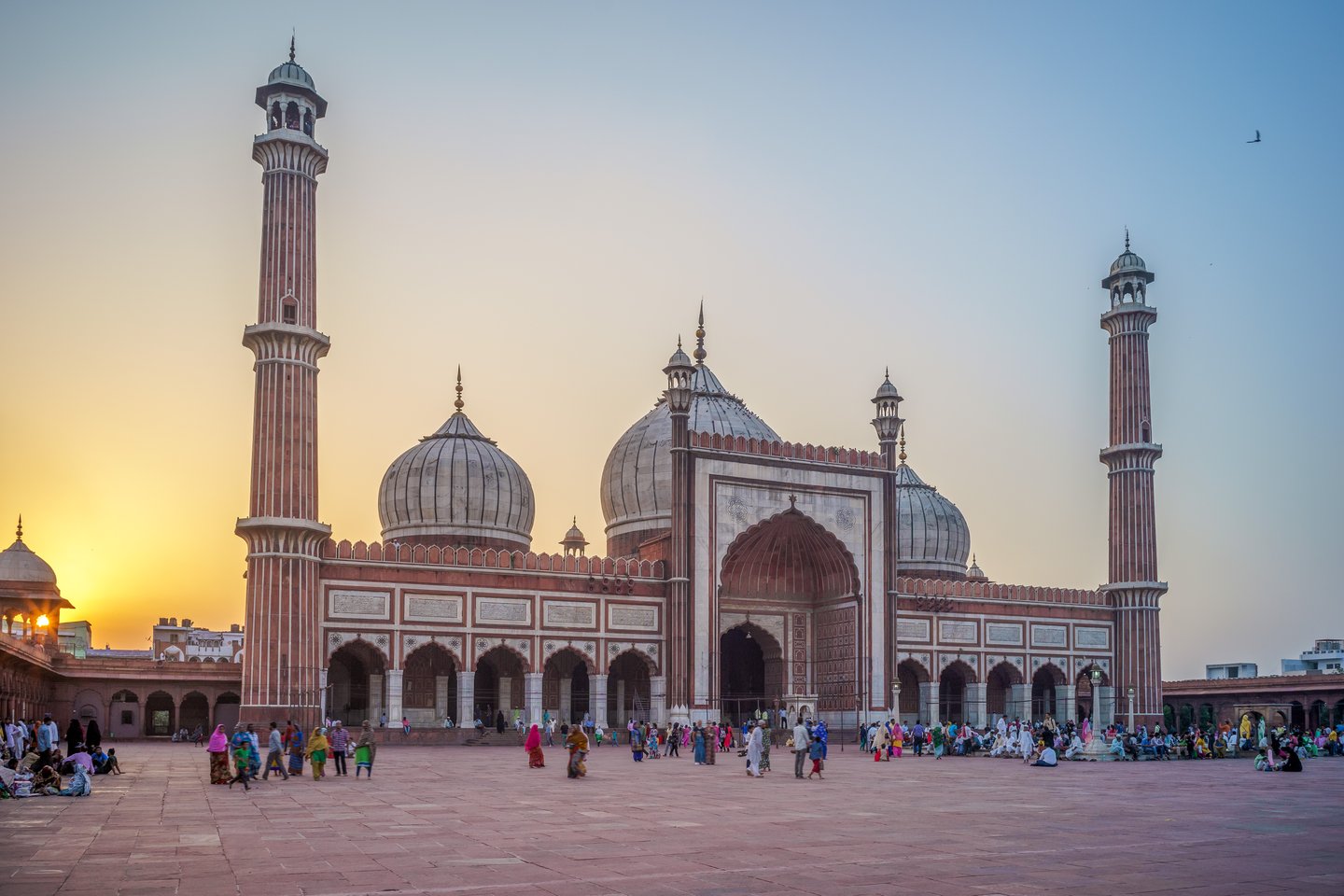 People walking in front of the Jama Masjid in Delhi at sunrise