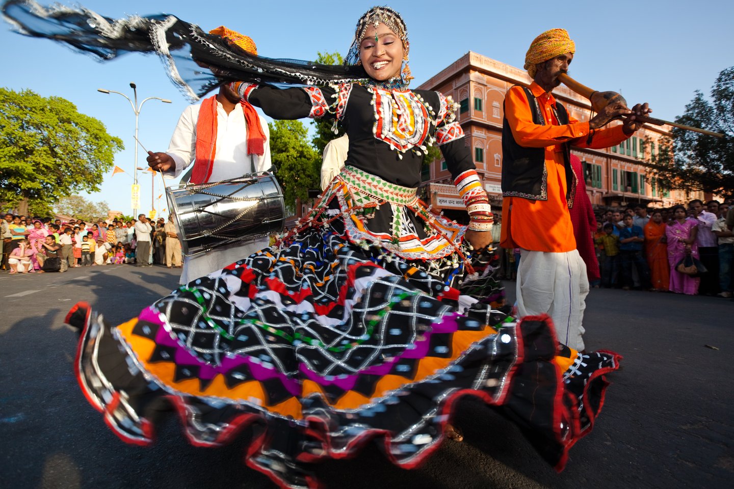 A woman and musicians performing at the Gangaur Festival in Jaipur