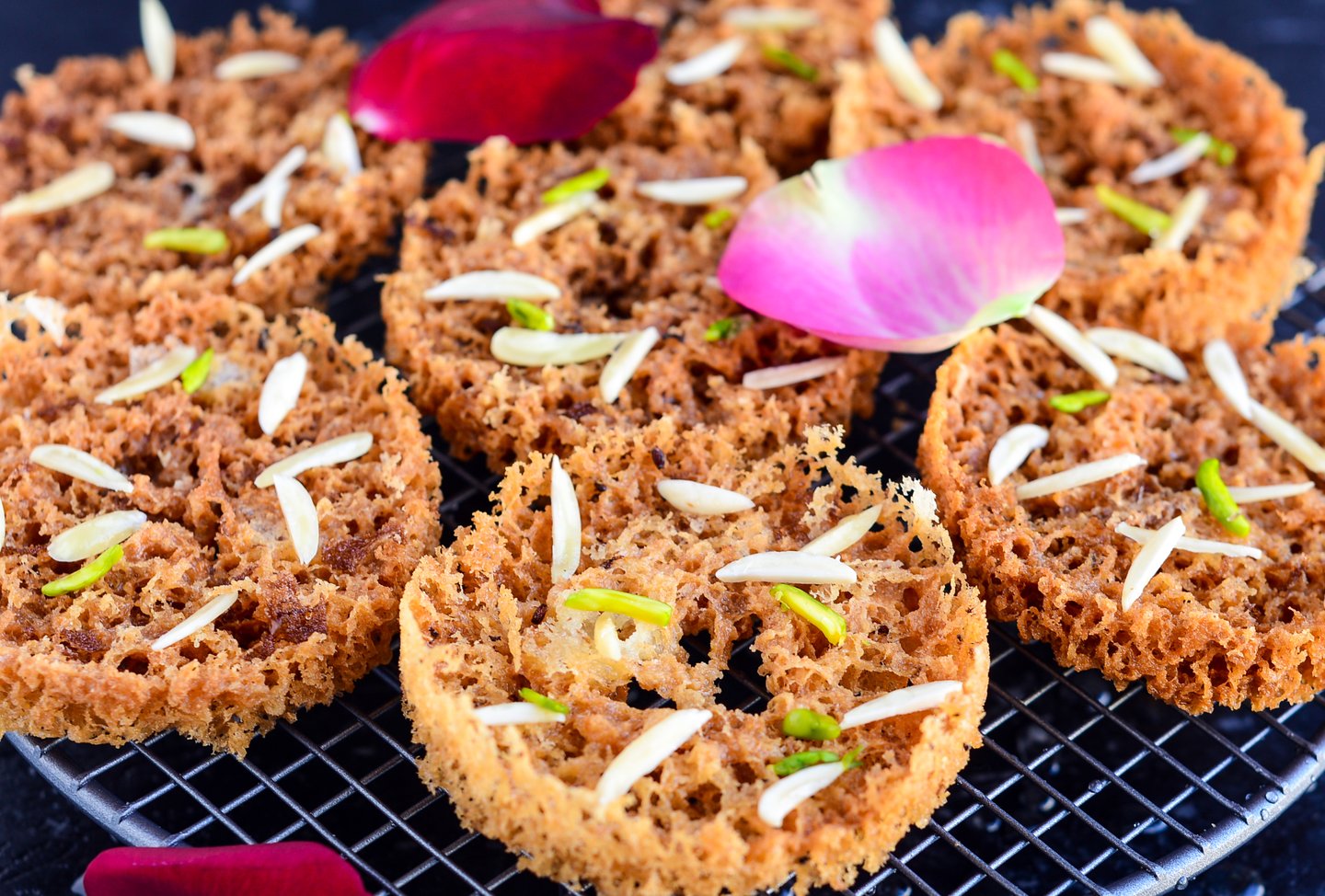 Ghevar, a local sweet, on a tray scattered with rose petals
